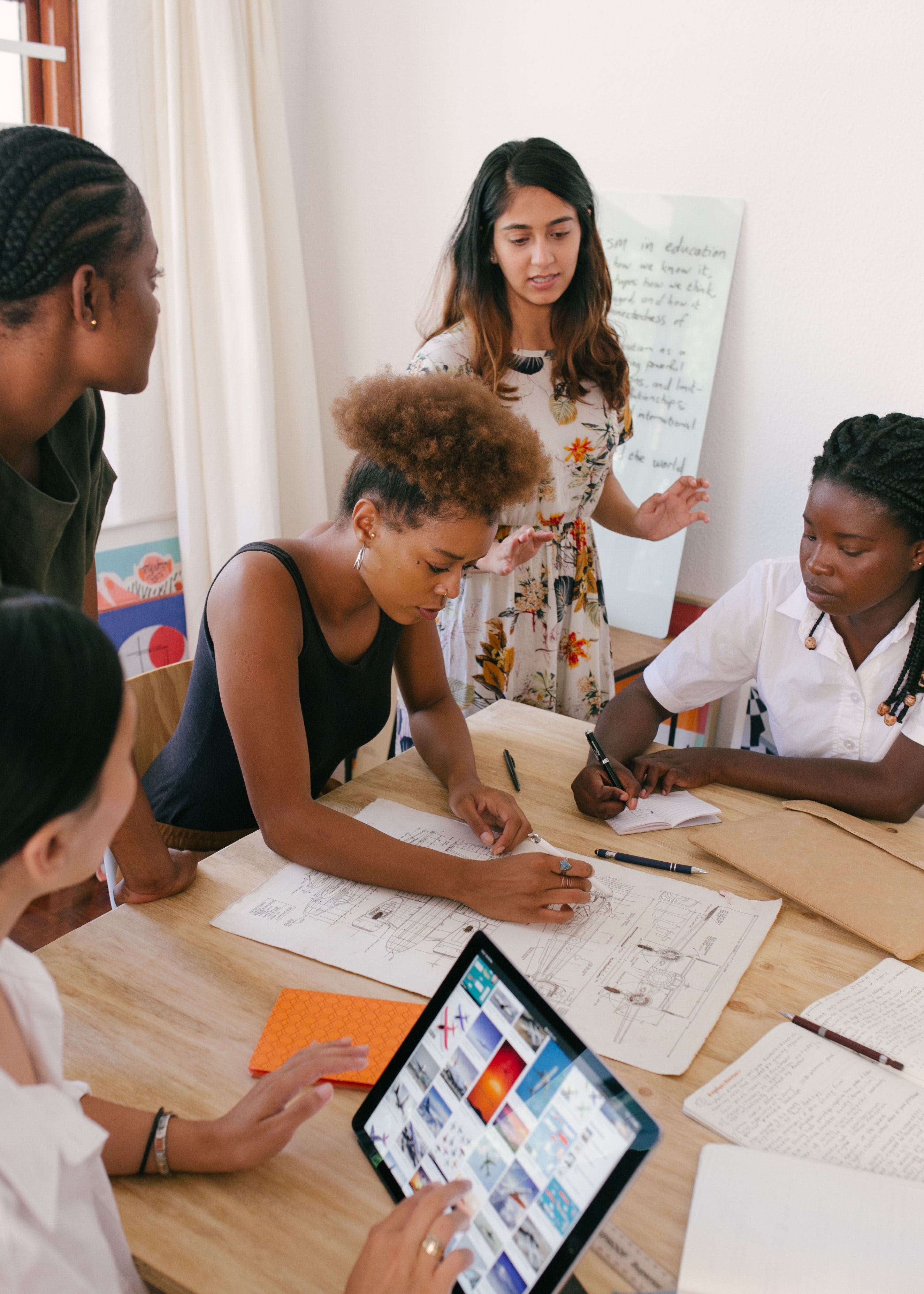 group of people surrounding a table discussing work